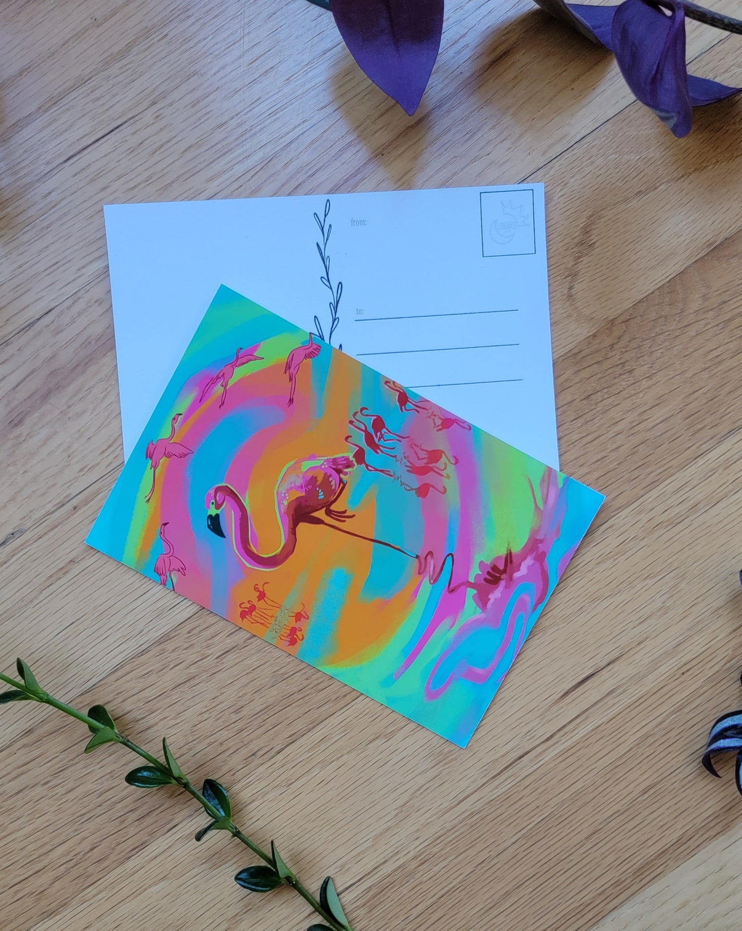 a photo of two post cards, one overlapping the other. Plants frame the image.