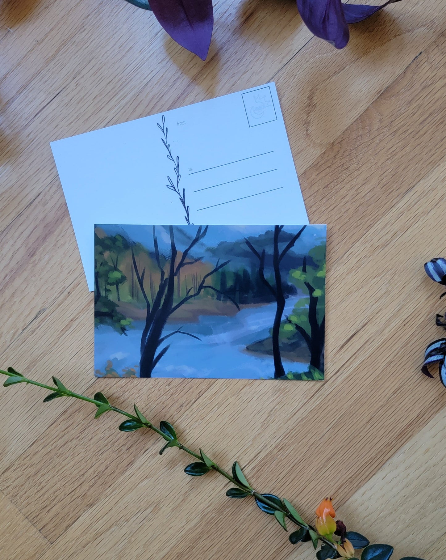 a photo of two post cards, one overlapping the other. Plants frame the image.