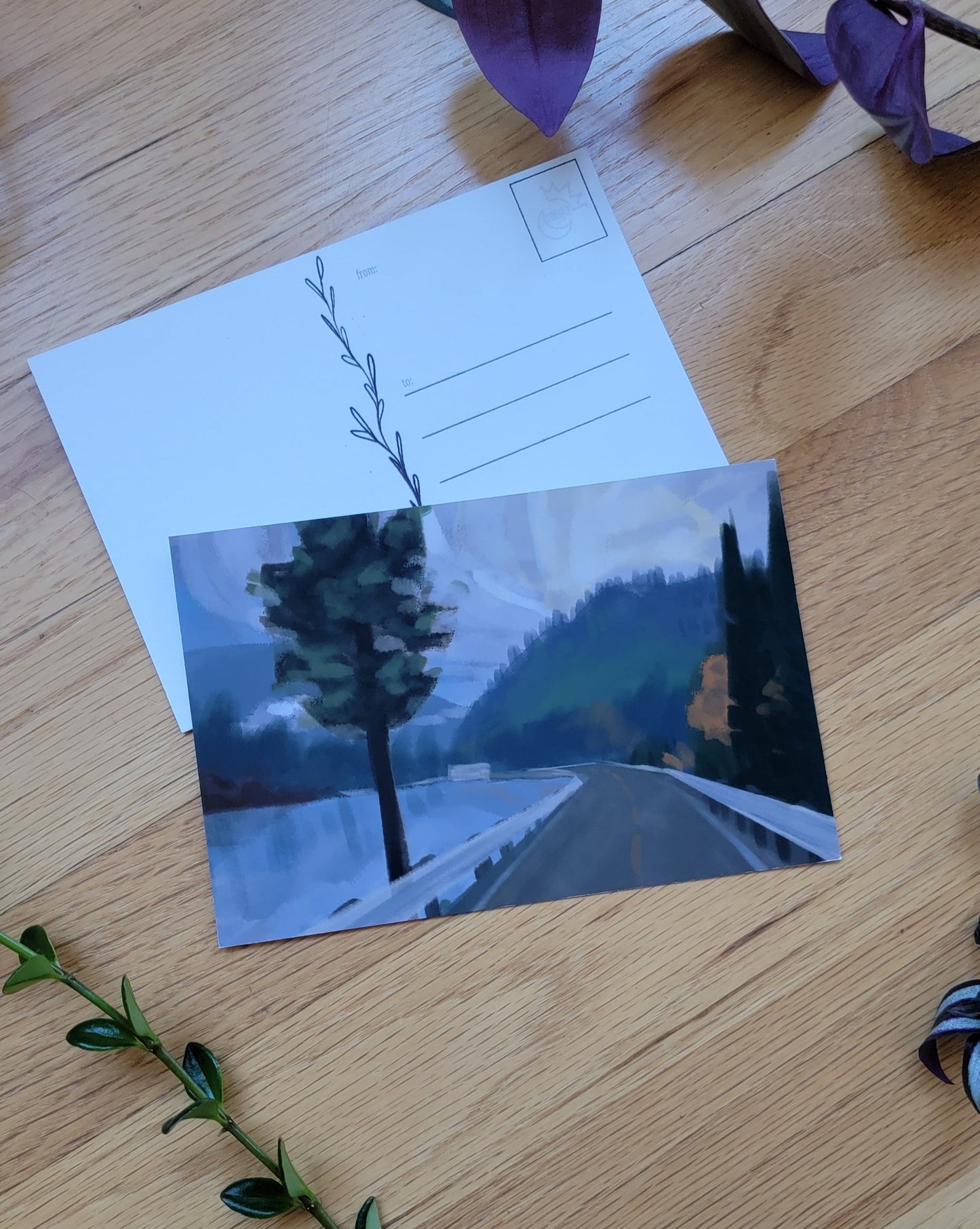 a photo of two post cards, one overlapping the other. Plants frame the image.