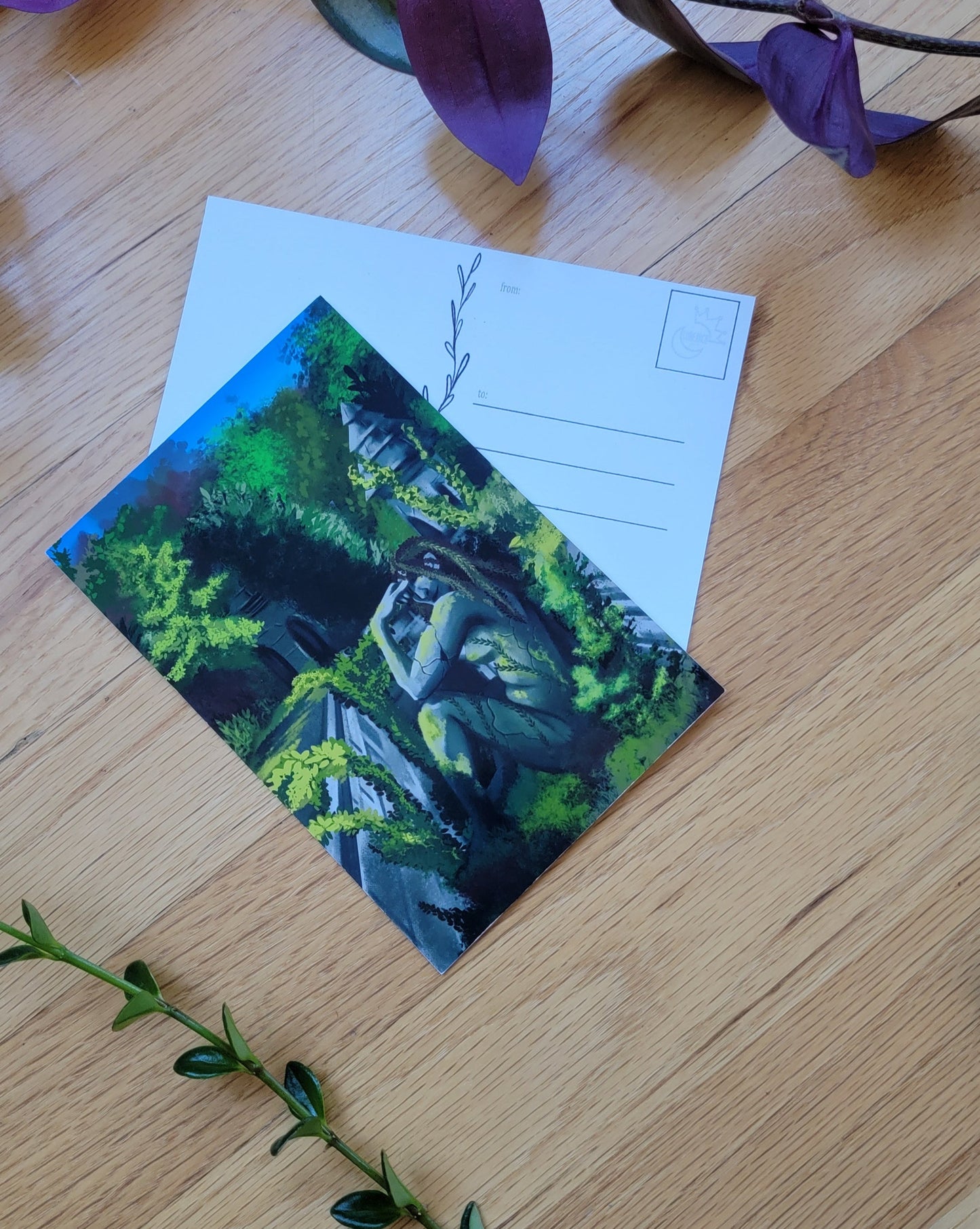 a photo of two post cards, one overlapping the other. Plants frame the image.