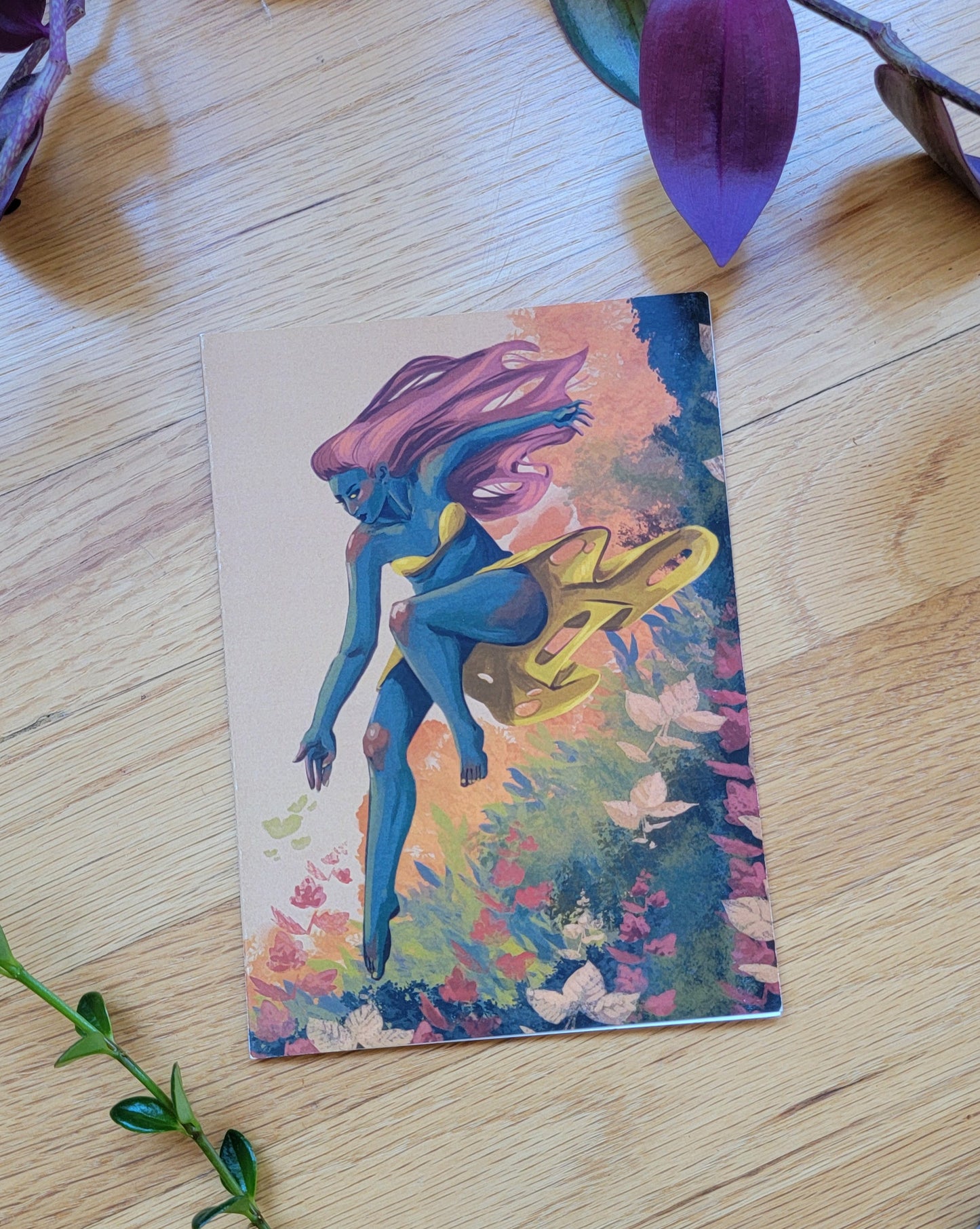 some plants frame a greeting card, laying closed so the front is visible.