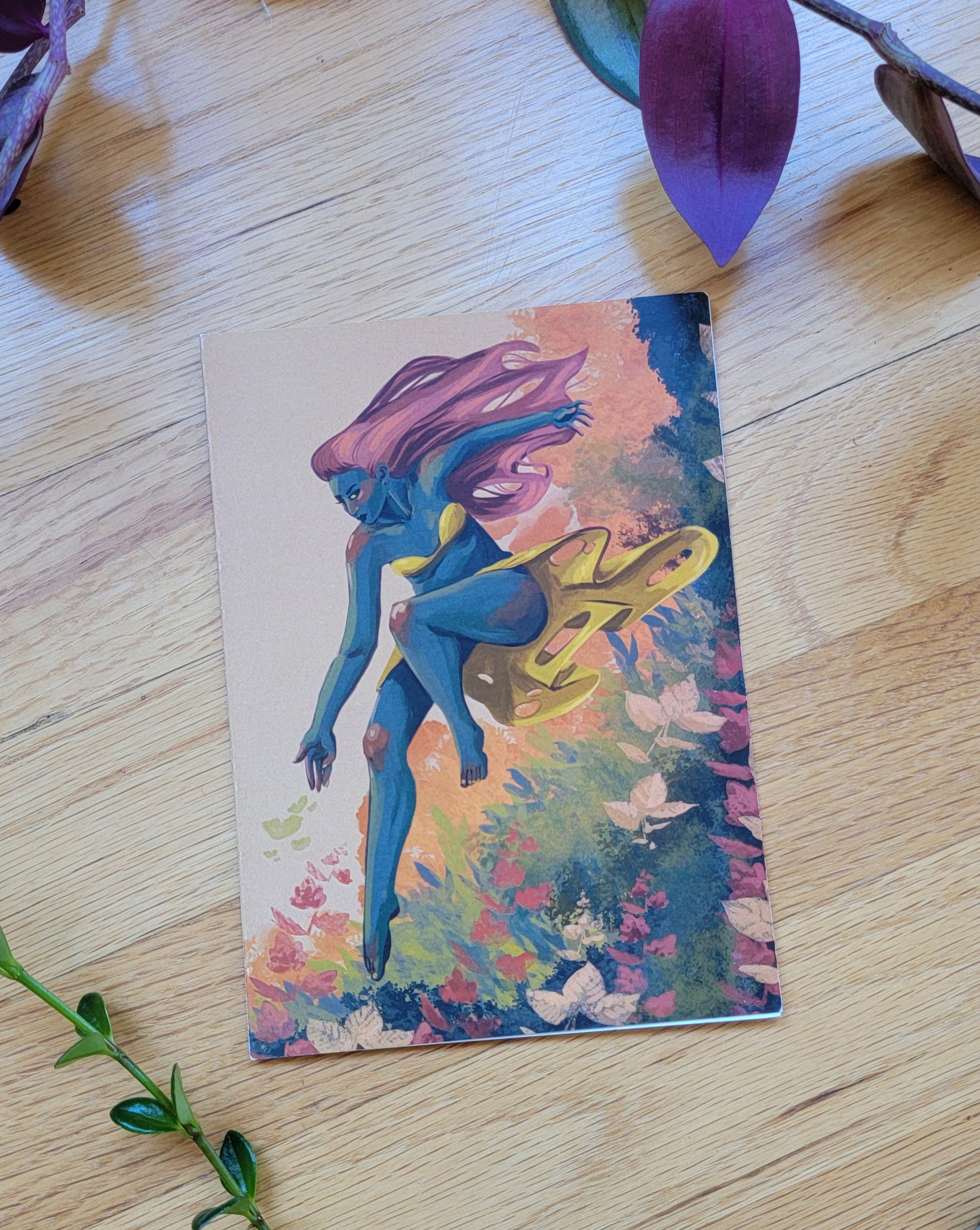some plants frame a greeting card, laying closed so the front is visible.