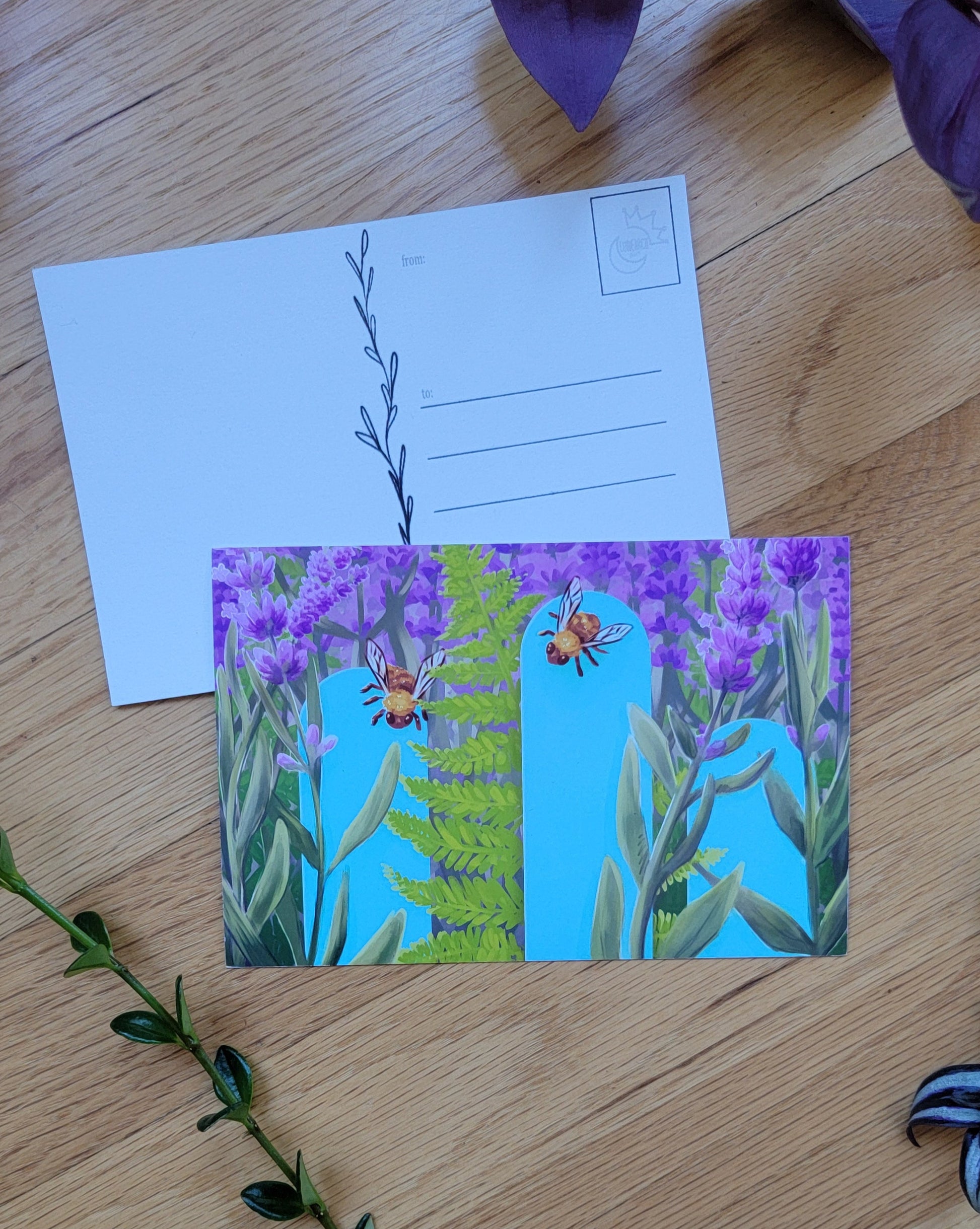 a photo of two post cards, one overlapping the other. Plants frame the image.